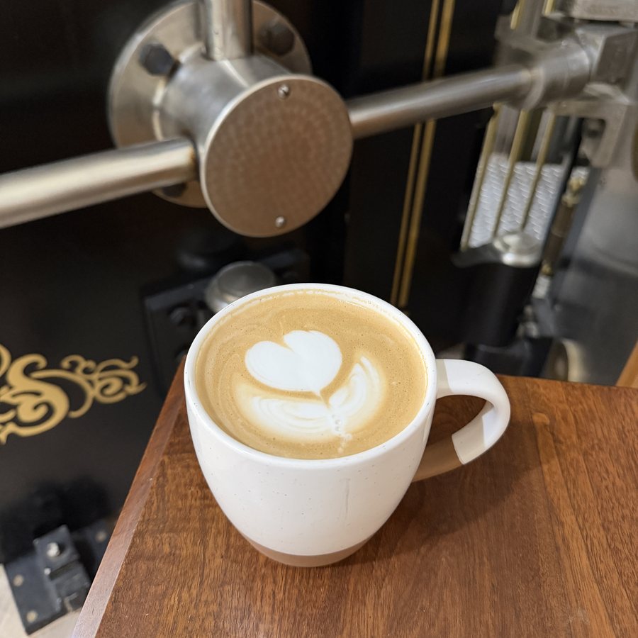 Latte with heart art in front of the original vault door