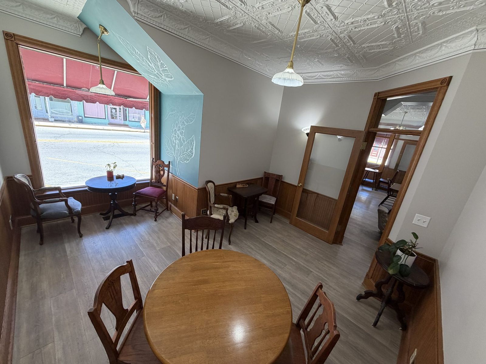 Side room with antique tables and wainscoting