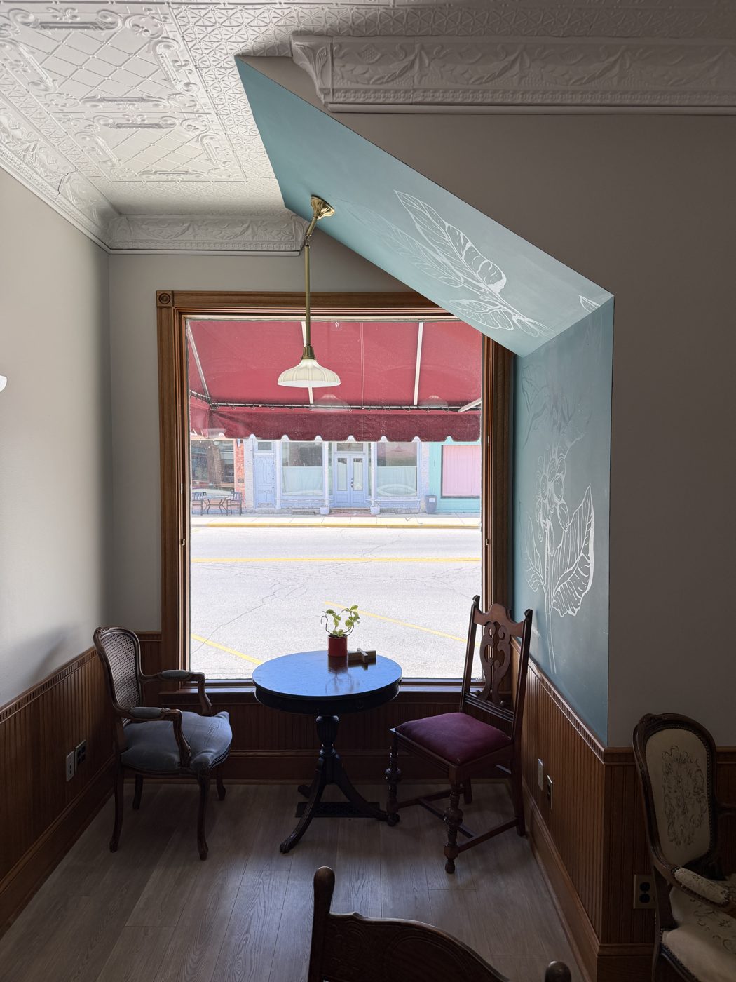 Window nook with hand-painted coffee plant mural